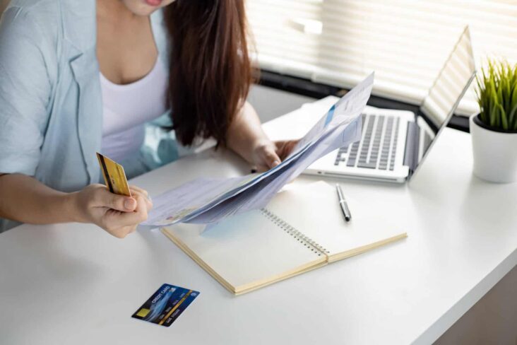 mulher a analisar os seus contratos de crédito, após fazer um check up às suas finanças pessoais