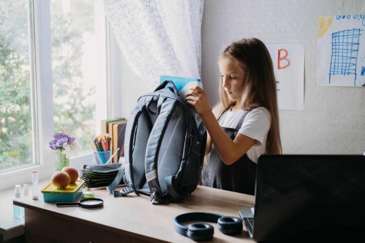 criança a preparar a mochila para voltar à escola, a ilustrar a necessidade de alguns pais recorrem a um crédito pessoal no regresso às aulas