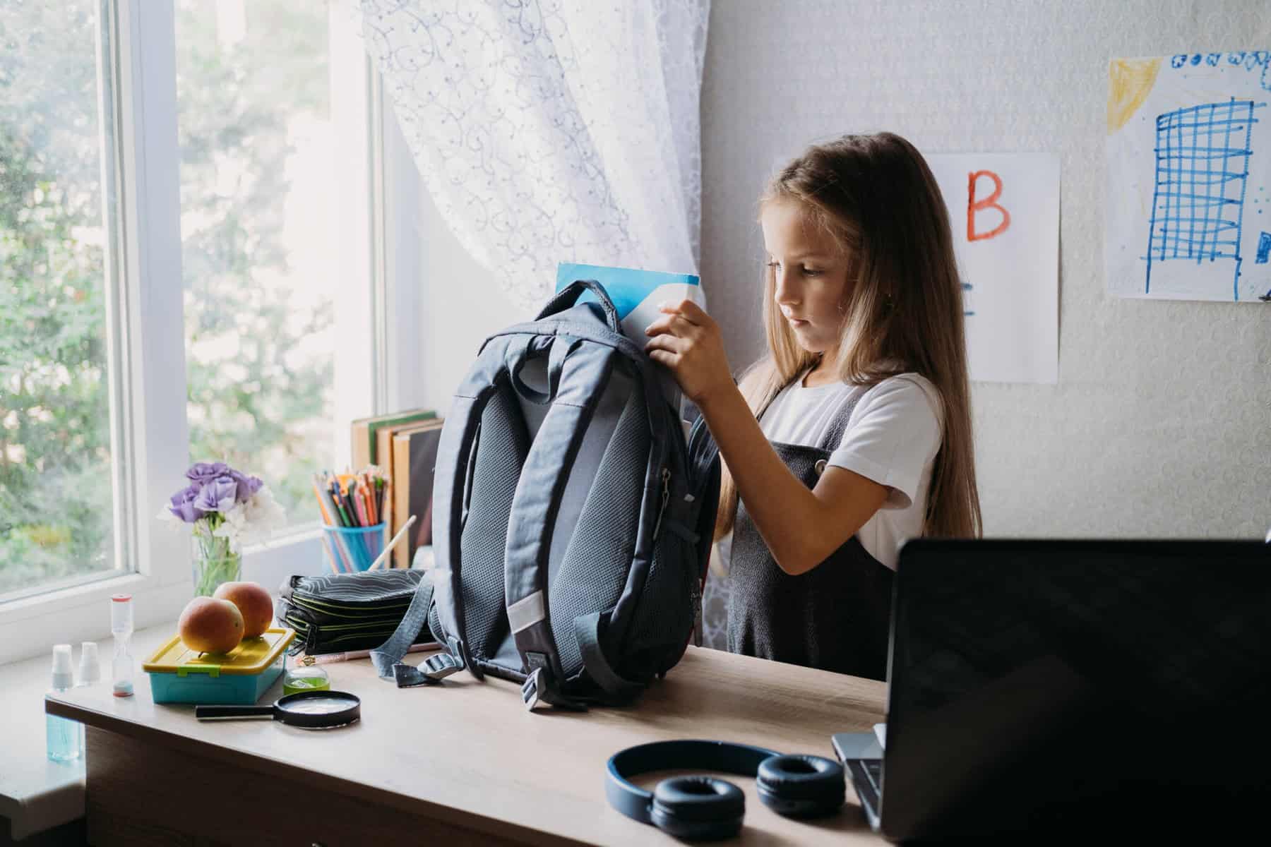 criança a preparar a mochila para voltar à escola, a ilustrar a necessidade de alguns pais recorrem a um crédito pessoal no regresso às aulas