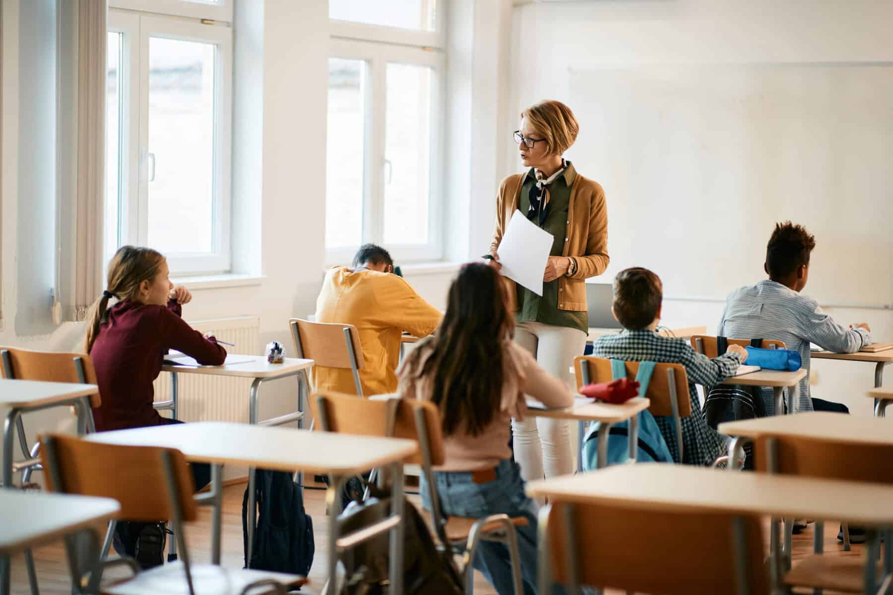 docente numa sala de aulas com os alunos atrás a ilustrar Alojamento para professores deslocados