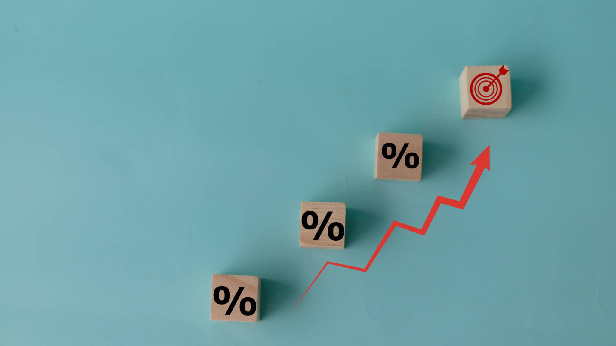 dados com o símbolo de percentagem e uma seta vermelha a subir a ilustrar que os juros no crédito ao consumo subiram e continuam em níveis elevados, mas o aumento não é tão expressivo