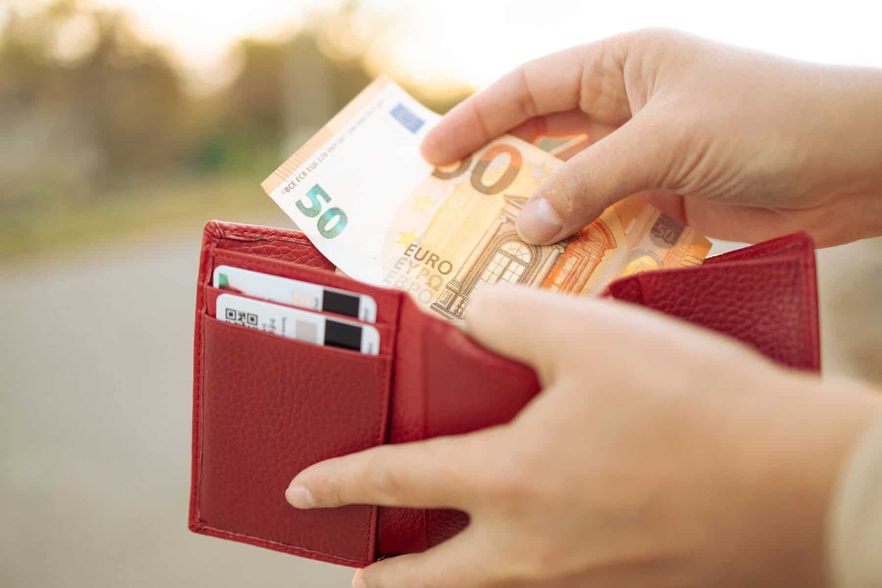 mulher a guardar nota de 50 euros na carteira