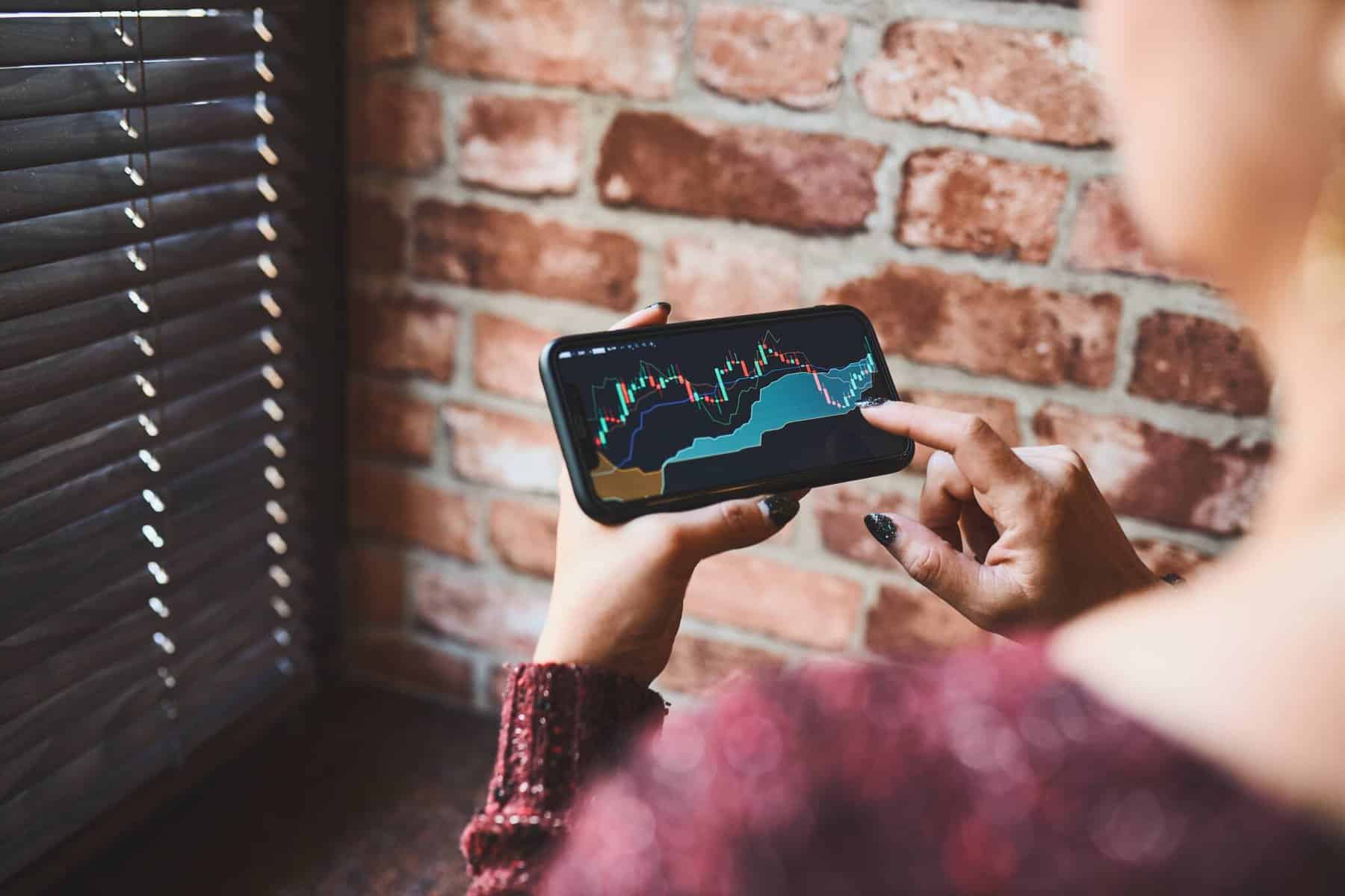 Jovem investidora consulta um gráfico para avaliar a evolução dos seus investimentos
