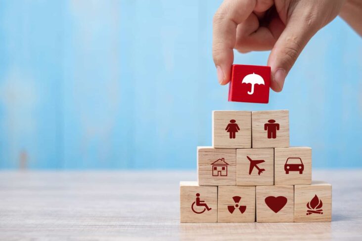 Pilha de cubos de madeira com desenhos relacionados com família, férias e seguros