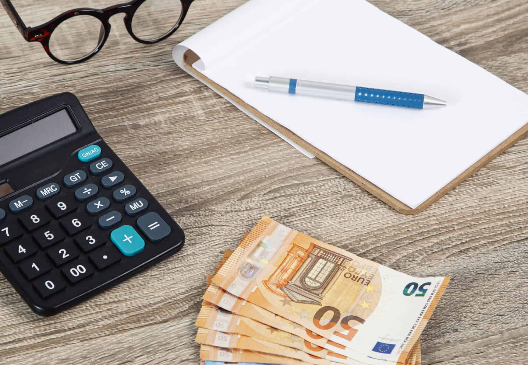 calculadora, notas e bloco com uma caneta a ilustrar a importância que os cálculos e a informação pode ter antes de contratar um crédito pessoal