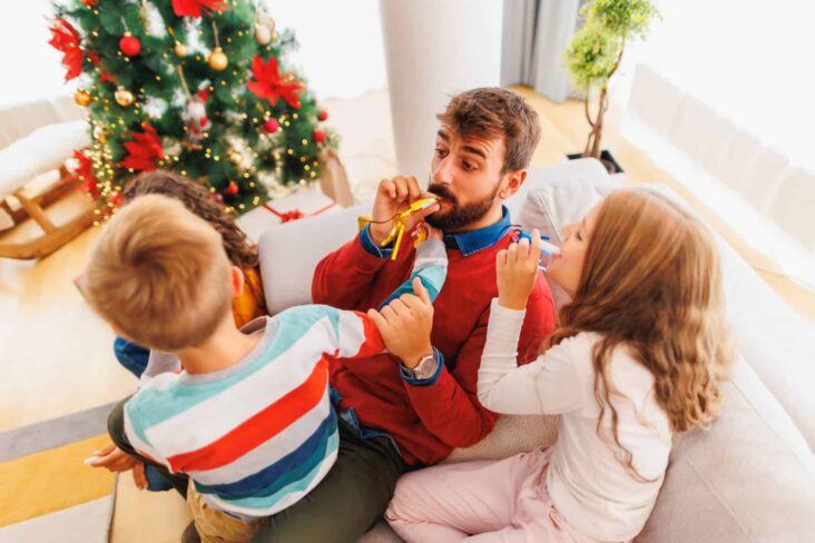 Pais a brincar com crianças no Natal