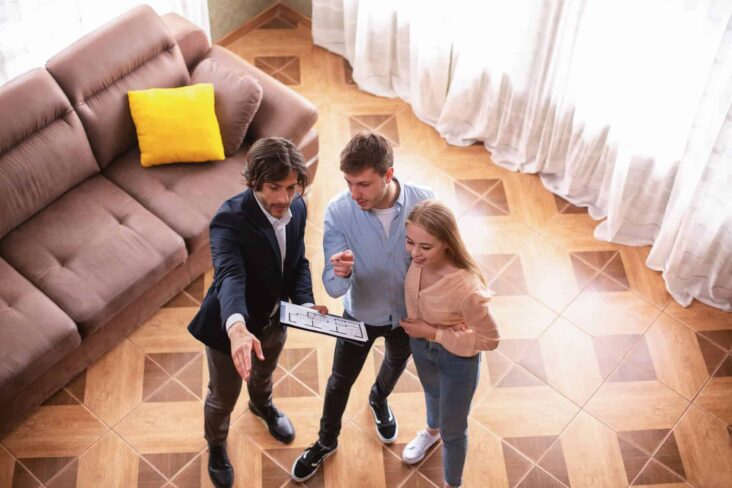 Casal a visitar casa e a tirar dúvidas com o agente imobiliário e a ter cuidado com alguns aspetos que devem ter em atenção