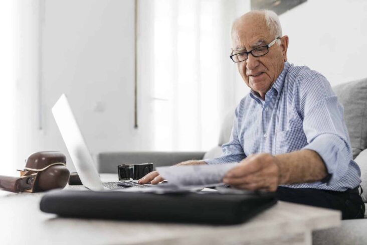 homem mais velho ao computador a fazer contas de quanto será o aumento extraordinário e permanente das pensões para 2025