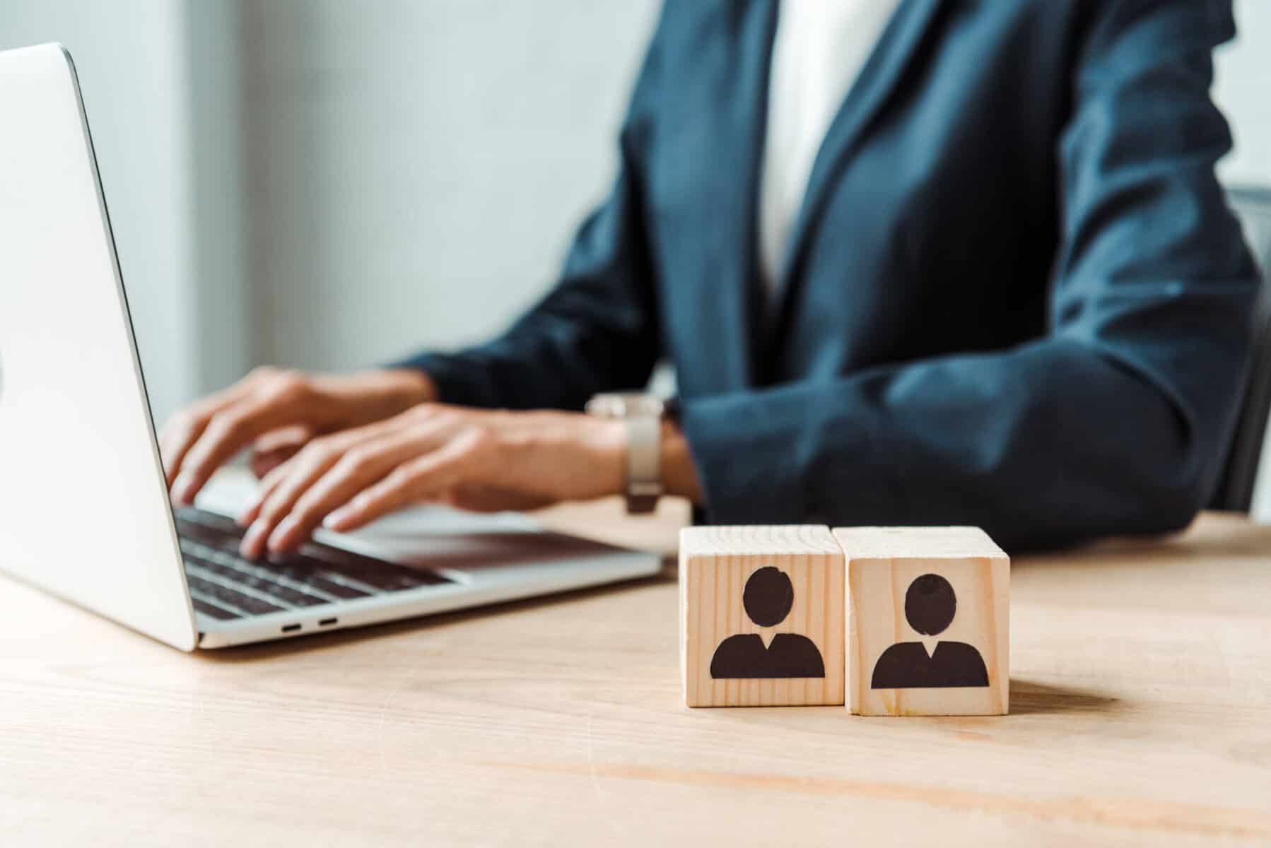 gestor de RH com dois cubos de madeiras cada um com o desenho de uma pessoa a ilustrar o que é o ATS e como é útil no processo de recrutamento