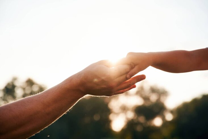 duas mãos encontram-se, num gesto de solidariedade