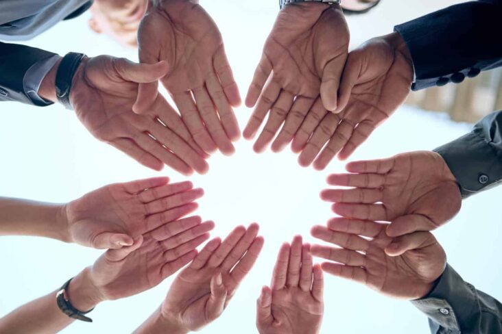 Várias mãos dispostas lado a lado, numa alusão a um evento de solidariedade