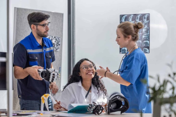 três jovens trabalhadores reunidos numa sala com objetos tecnológicos a ilustrar Profissões no futuro: Quais as áreas com maior potencial?