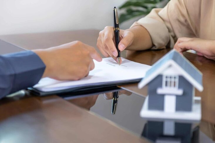 Duas mãos a assinar os documentos relativos ao crédito habitação ilustrando que a Procura de crédito habitação cresceu no primeiro trimestre de 2025