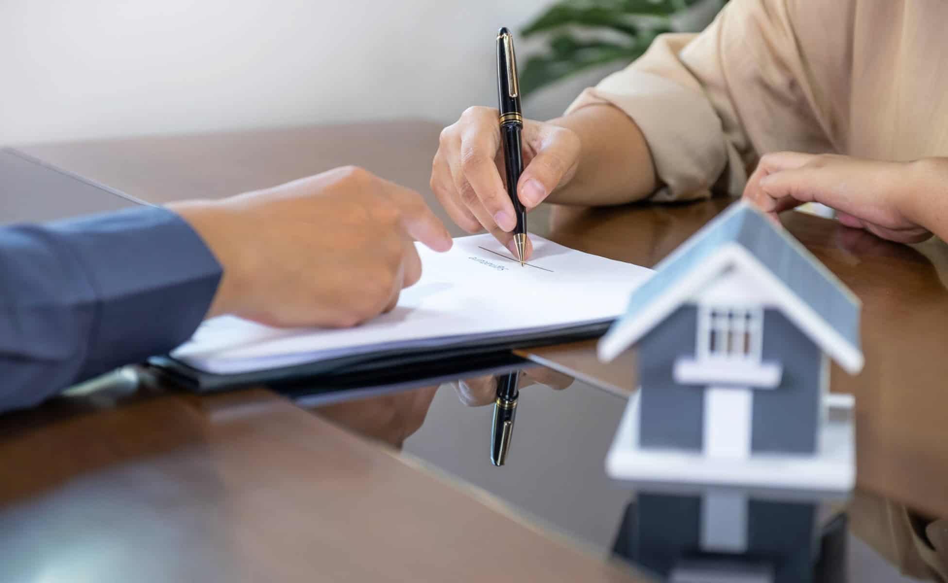 Duas mãos a assinar os documentos relativos ao crédito habitação ilustrando que a Procura de crédito habitação cresceu no primeiro trimestre de 2025