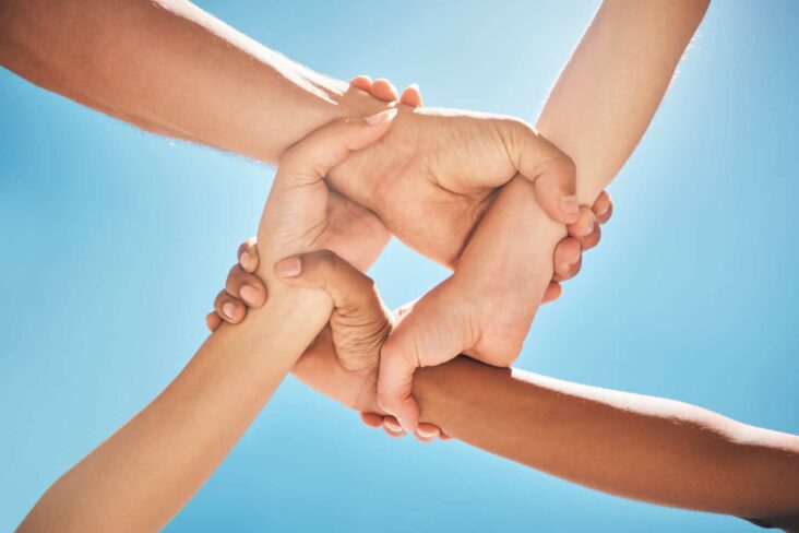 Quatro mãos ligadas, numa alusão à solidariedade